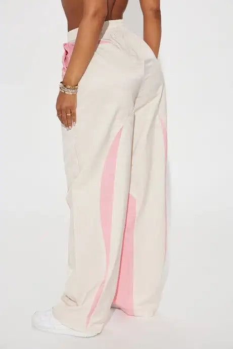 Beige wide-leg pants with pink wave panel detailing