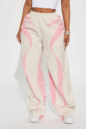 Beige wide-leg pants with pink wave panel detailing