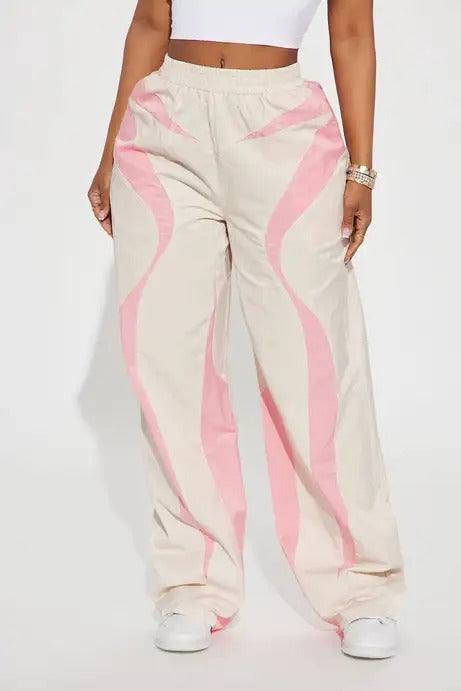 Beige wide-leg pants with pink wave panel detailing
